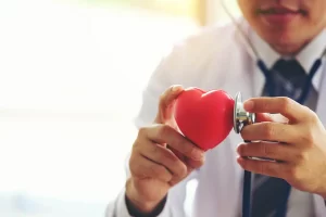 doctor-holding-hands-with-red-heart-in-clinic-offi-DQZJX8H